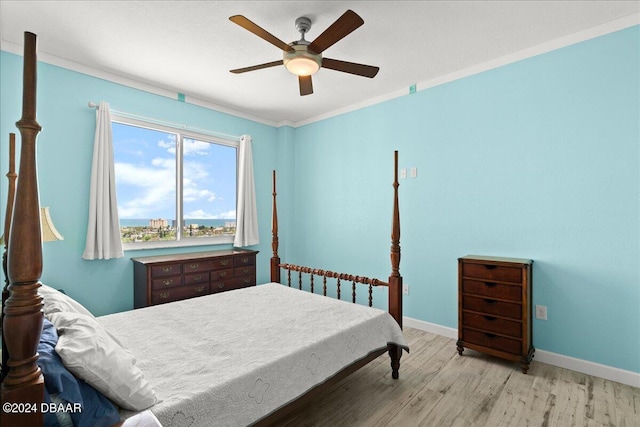 bedroom featuring light hardwood / wood-style flooring, ornamental molding, and ceiling fan