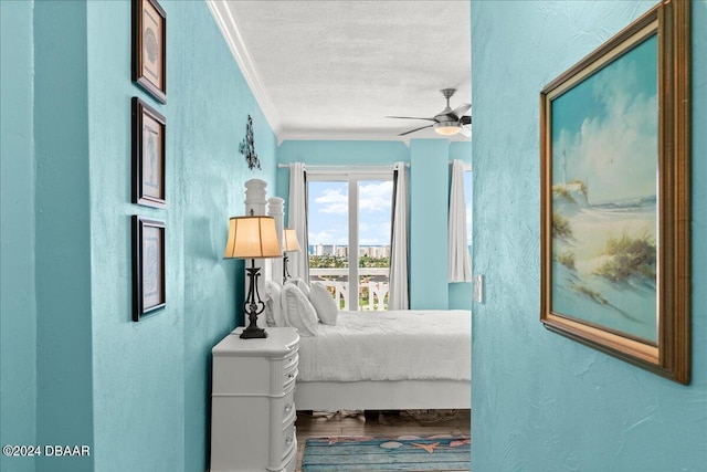 bedroom featuring hardwood / wood-style flooring, ceiling fan, crown molding, and a textured ceiling