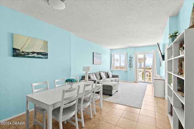 tiled dining room with a textured ceiling