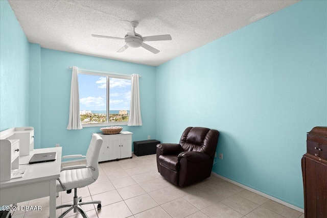 tiled office space featuring a textured ceiling and ceiling fan