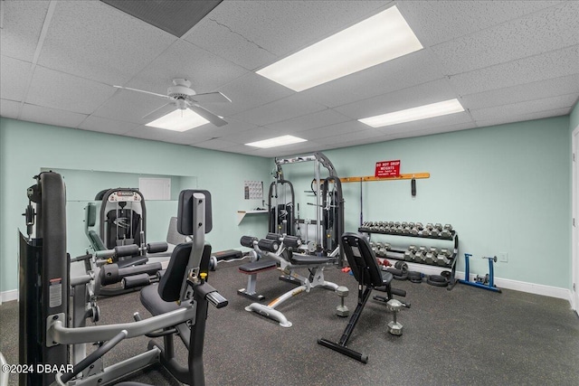 exercise room with a paneled ceiling and ceiling fan