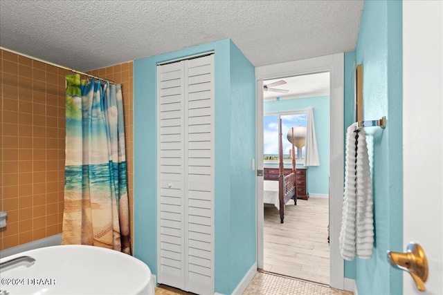 bathroom with ceiling fan and a textured ceiling