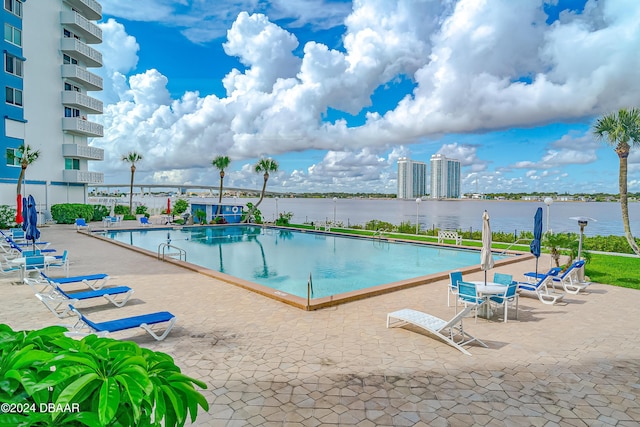 view of pool featuring a patio and a water view