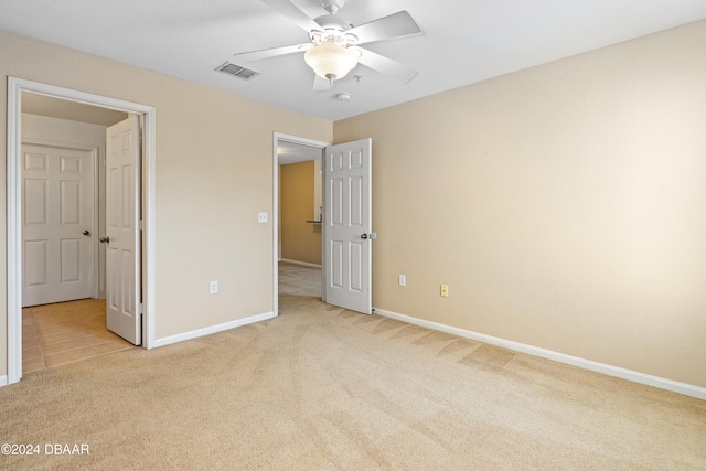 unfurnished bedroom featuring light colored carpet and ceiling fan