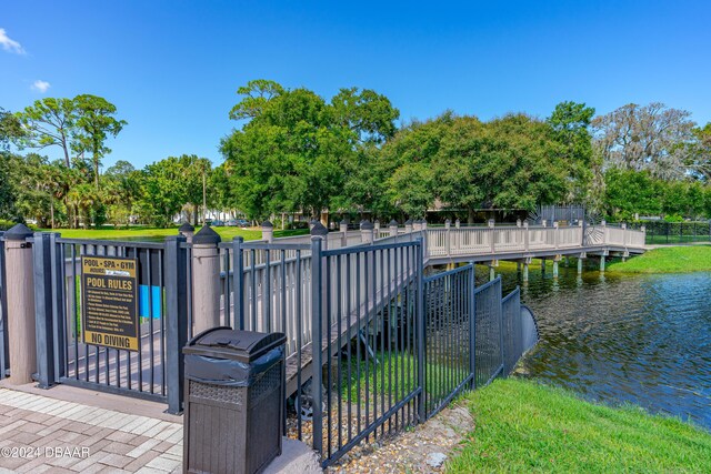 940 Village Trl Unit 3-203, Port Orange, FL 32127 - gate featuring fence, a water view, and view of wooded area
