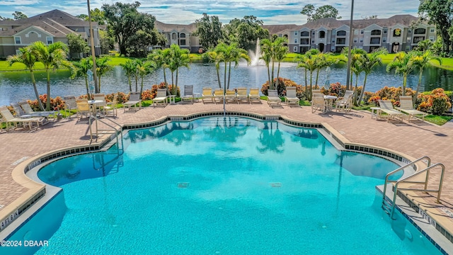 view of pool with a patio area and a water view