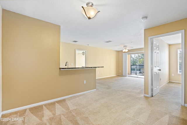 unfurnished room featuring light colored carpet and ceiling fan