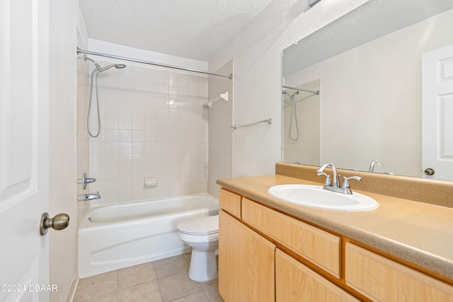 full bathroom with tiled shower / bath, a textured ceiling, vanity, tile patterned floors, and toilet