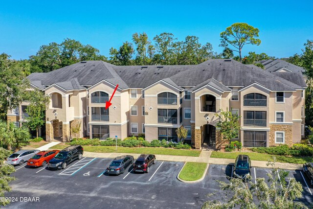 940 Village Trl Unit 3-203, Port Orange, FL 32127 - view of building exterior with uncovered parking