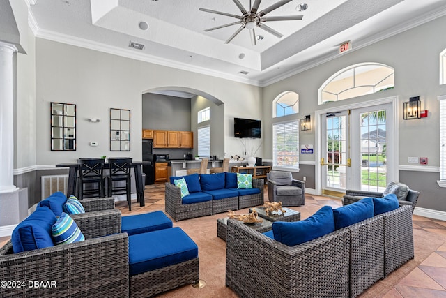 940 Village Trl Unit 3-203, Port Orange, FL 32127 - living room featuring a tray ceiling, a ceiling fan, a high ceiling, crown molding, and decorative columns