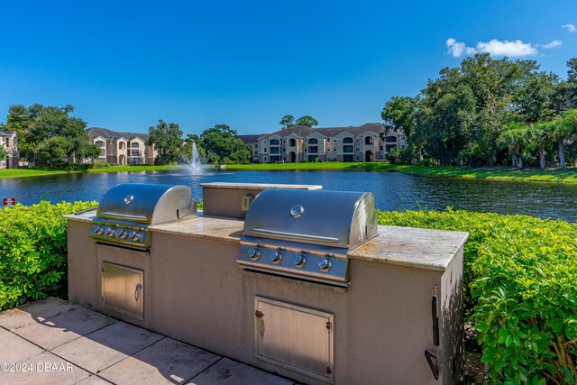 940 Village Trl Unit 3-203, Port Orange, FL 32127 - view of patio / terrace featuring a grill, an outdoor kitchen, and a water view