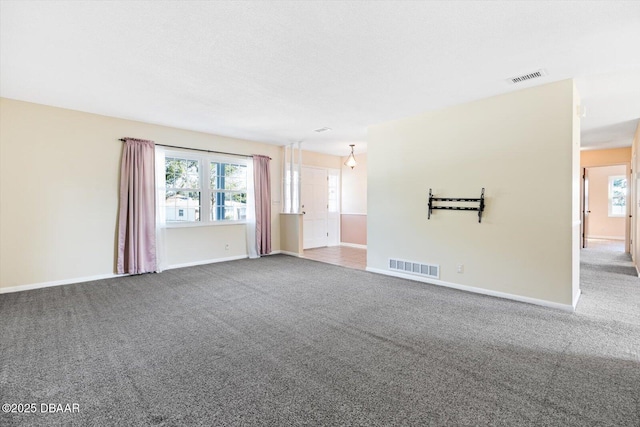 carpeted empty room with a wealth of natural light and a textured ceiling