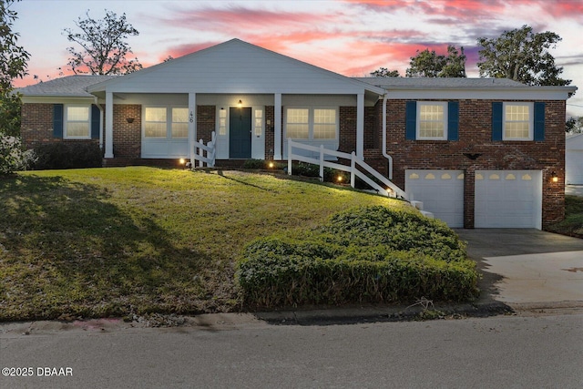 view of front of house featuring a garage and a lawn