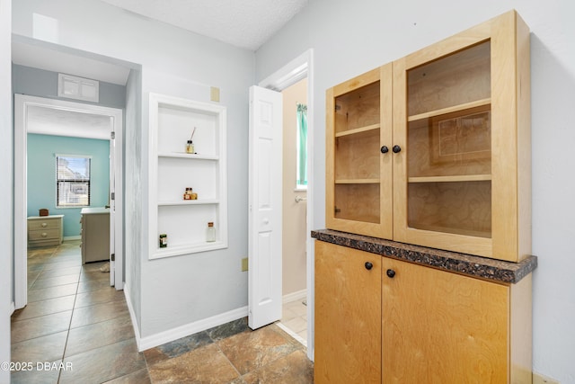 corridor featuring built in shelves and a textured ceiling