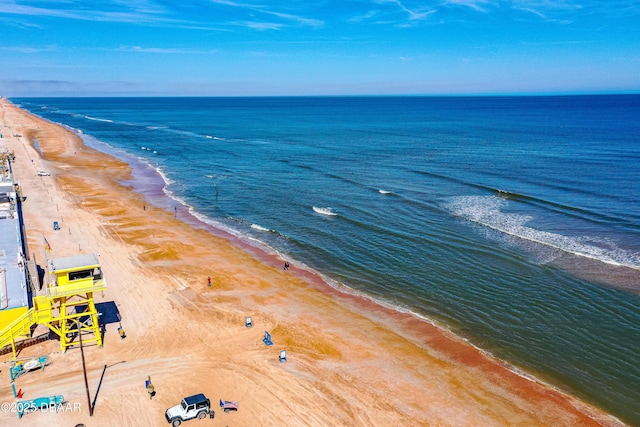 drone / aerial view featuring a beach view and a water view