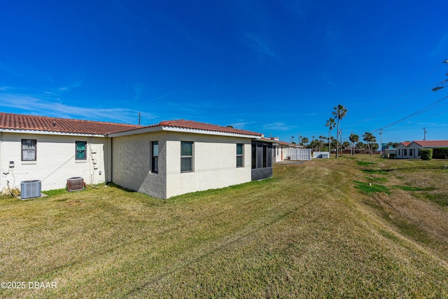 rear view of property featuring a yard and cooling unit