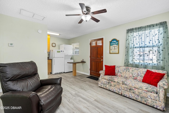 living room featuring ceiling fan, a textured ceiling, and light hardwood / wood-style flooring