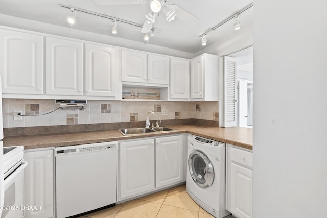 kitchen featuring white cabinets, dishwasher, washer / clothes dryer, sink, and light tile patterned flooring