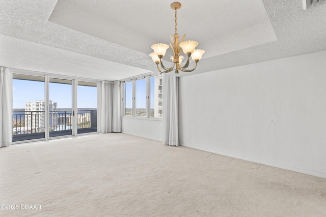 spare room with a notable chandelier and carpet flooring