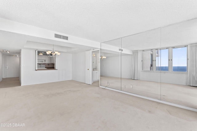 basement with carpet, a notable chandelier, and a textured ceiling