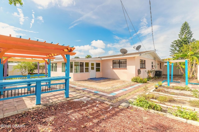 rear view of property featuring cooling unit, a pergola, and a patio area