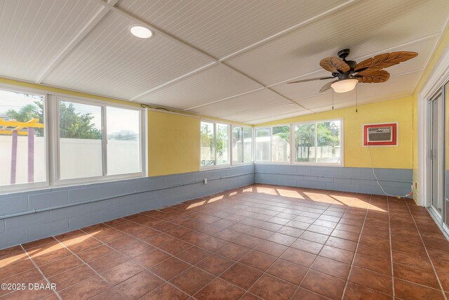 unfurnished sunroom featuring a wall mounted air conditioner and ceiling fan