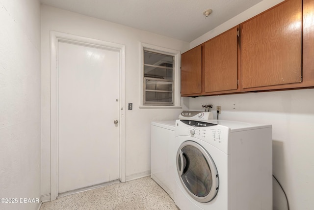 washroom with cabinets and washer and dryer