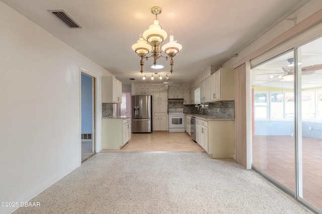 kitchen featuring sink, decorative light fixtures, appliances with stainless steel finishes, decorative backsplash, and white cabinets