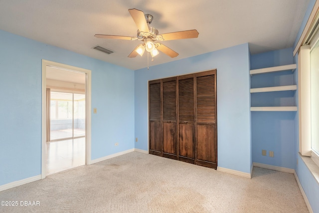 unfurnished bedroom featuring ceiling fan, a closet, and light carpet