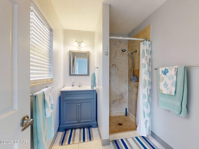 bathroom featuring a tile shower, vanity, and tile patterned floors