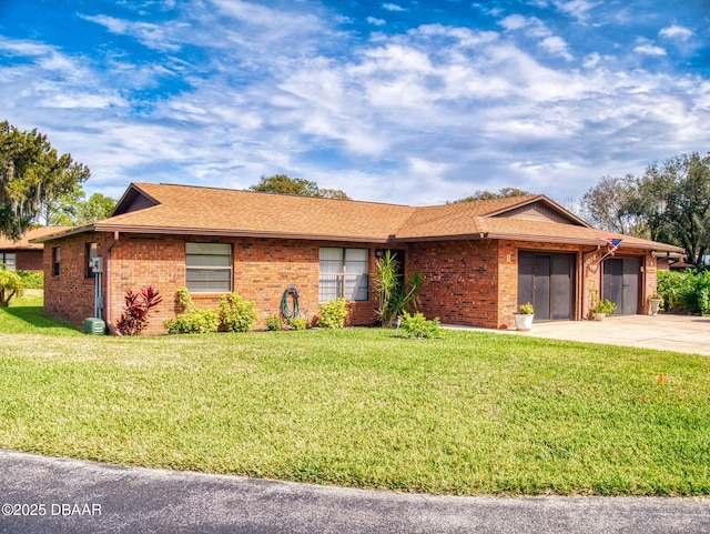 ranch-style house featuring brick siding, a shingled roof, a garage, driveway, and a front lawn