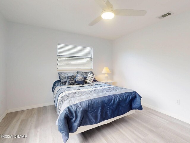 bedroom with visible vents, baseboards, ceiling fan, and wood finished floors