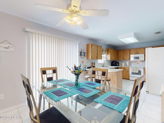 dining room with light tile patterned floors, baseboards, visible vents, and a ceiling fan