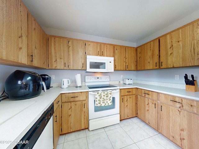 kitchen featuring white appliances, light tile patterned floors, and light countertops