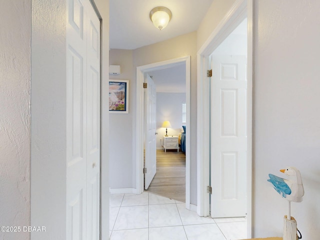 hallway featuring light tile patterned floors and baseboards