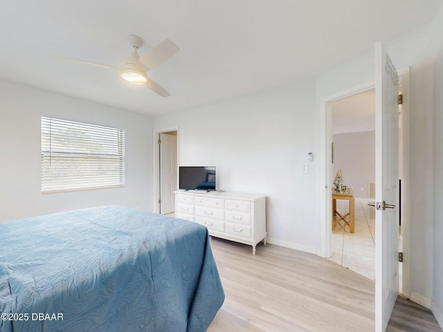 bedroom with light wood-style floors, ceiling fan, and baseboards