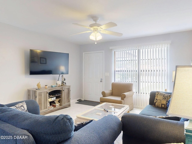 living room with ceiling fan and baseboards