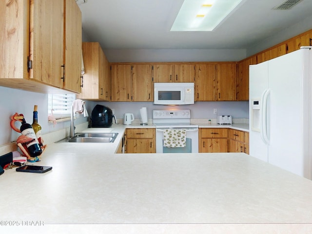 kitchen featuring white appliances, visible vents, a peninsula, light countertops, and a sink