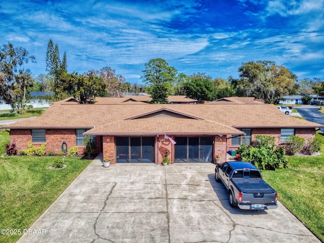 single story home featuring driveway, brick siding, a shingled roof, and a front yard