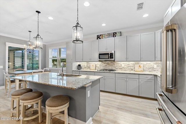 374 Lost Shaker Way, Daytona Beach, FL 32124 - kitchen featuring appliances with stainless steel finishes, a sink, backsplash, a center island with sink, and a kitchen bar