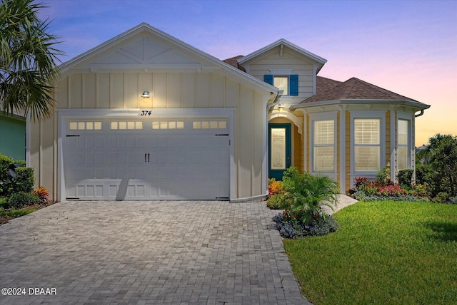 374 Lost Shaker Way, Daytona Beach, FL 32124 - view of front of home with an attached garage, decorative driveway, a lawn, and a shingled roof