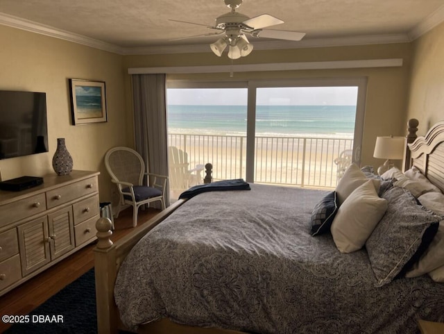 bedroom featuring a water view, access to exterior, a beach view, and ornamental molding