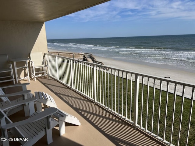 balcony featuring a water view and a beach view