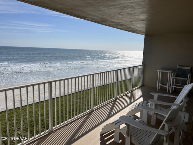 balcony with a beach view and a water view