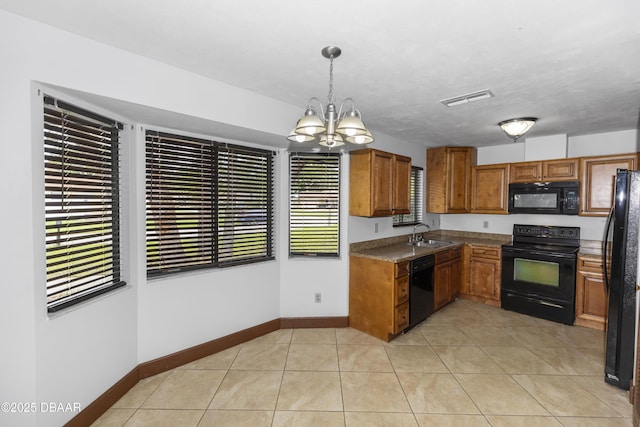 909 Brookside Dr, Ormond Beach, FL 32174 - kitchen with black appliances, brown cabinets, a sink, a chandelier, and baseboards