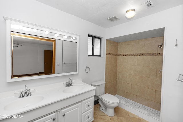 909 Brookside Dr, Ormond Beach, FL 32174 - bathroom with double vanity, toilet, a tile shower, and tile patterned flooring