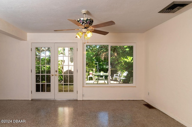 empty room featuring french doors, a textured ceiling, and ceiling fan