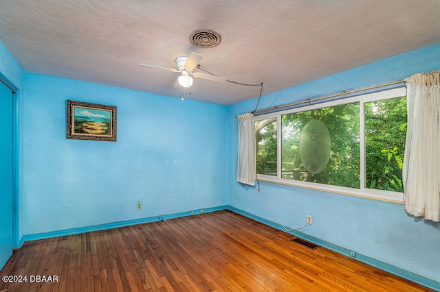 spare room featuring a textured ceiling, hardwood / wood-style flooring, and ceiling fan