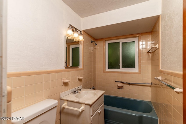 full bathroom with vanity, toilet, tile walls, and tiled shower / bath combo