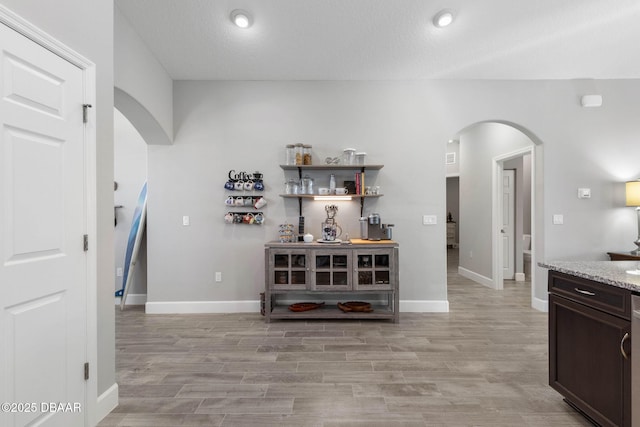 5 Chippeway Ct, Palm Coast, FL 32137 - bar area featuring arched walkways, light wood-style floors, baseboards, and recessed lighting